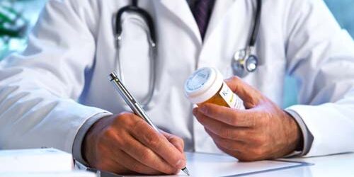 doctor writing prescription in medication assisted treatment program