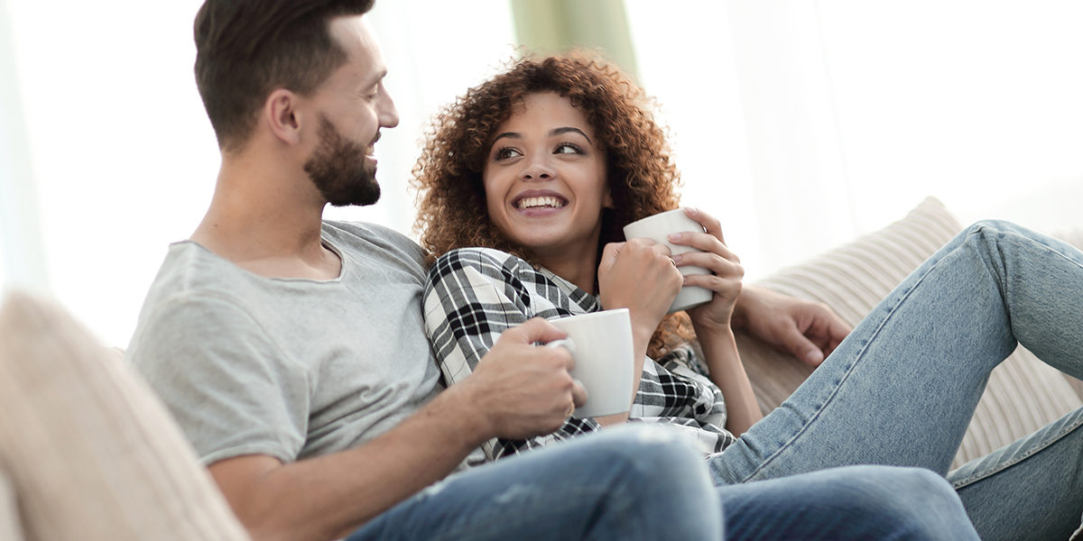 couple drinking coffee on couch knowing the importance of drug detox